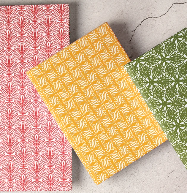 Moji Salehi’s Odyssey Collection of hand-printed home and lifestyle products, including cushions, lampshades, wallpaper, gift wraps, notebooks, and silk scarves, featuring intricate patterns inspired by Persian heritage and contemporary design.